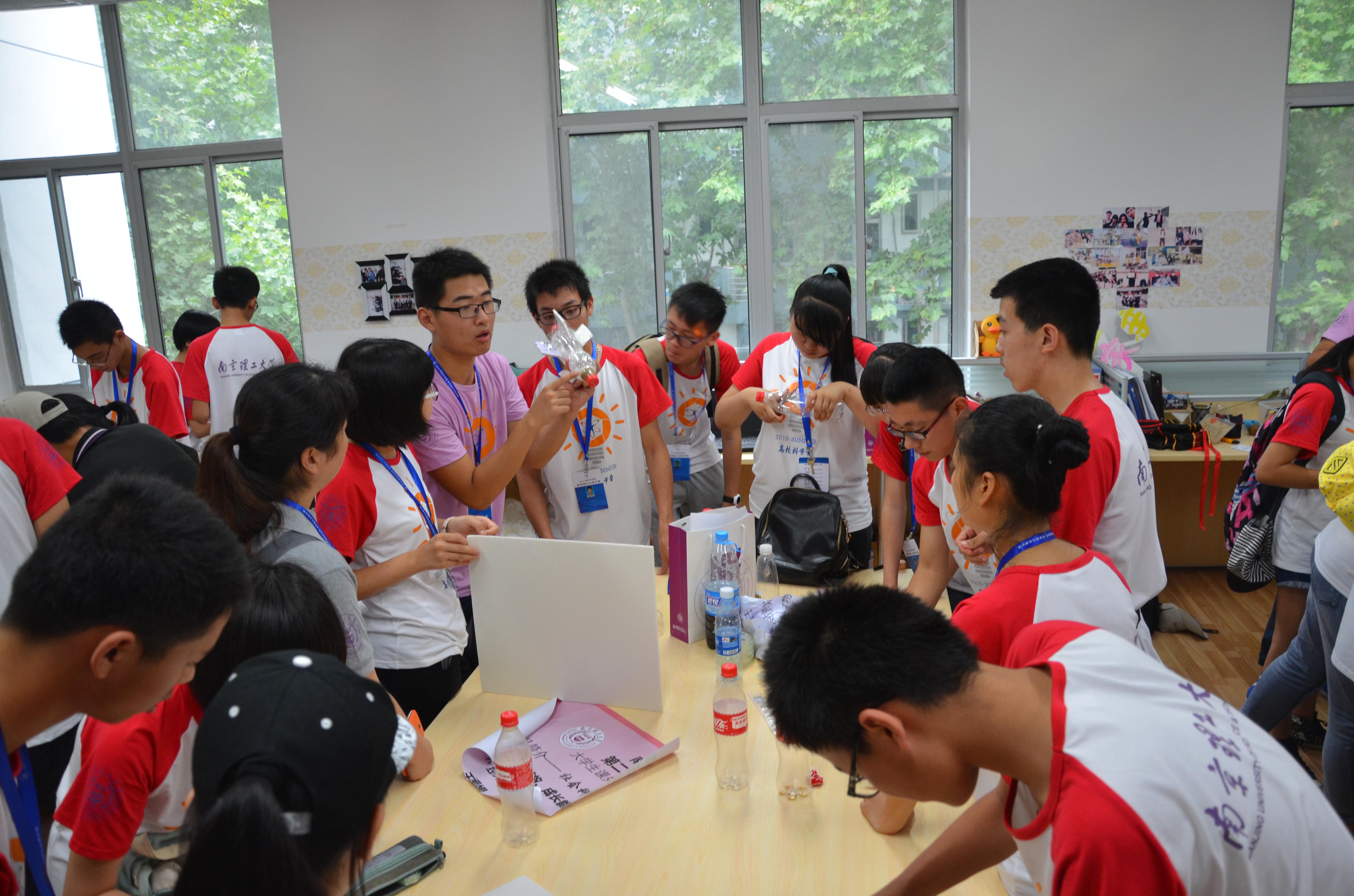 发射吧!水火箭 2015年科学营南京理工大学分营水火箭比赛 2015年7月16日下午,虽然天空一片阴霾,但是并不会影响2点开始的水火箭制作决赛。这是2015年全国青少年高校科学营南京理工大学分营举行了一次水火箭大赛,参赛同学创意无限,造型各异的水火箭给这无趣的天空增色不少。50只水火箭,数十个发射器同时发射,场面十分壮观。这些参赛作品都是一小时前在南理工科协志愿者们的指导下,营员们分组进行,用事先准备好的可乐瓶,通过切割、裁减,完成了水火箭的主体部分。在咨询了志愿者们相关发射事宜之后,他们各进其能,发挥
